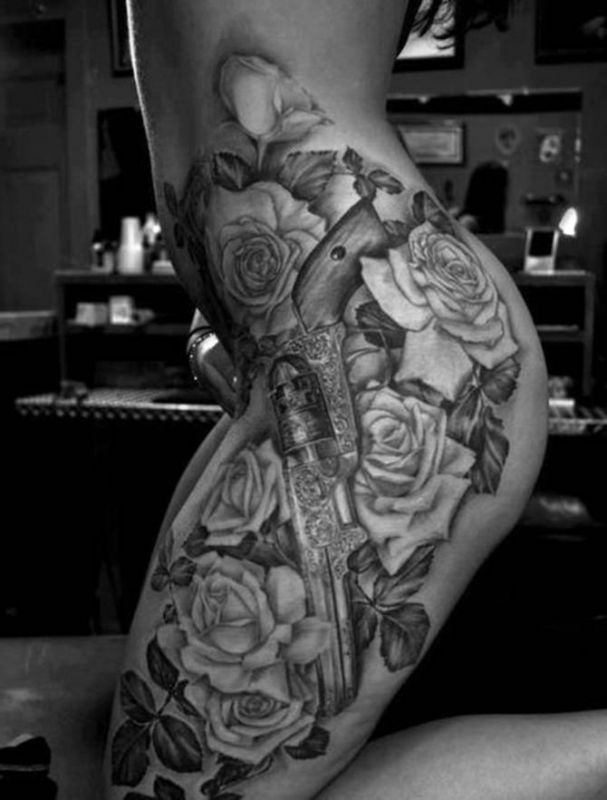 pistolet i róże tatuaże na bodrze