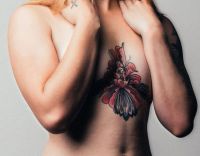kwiatek tatuaż na klatce piersiowej dla kobiety